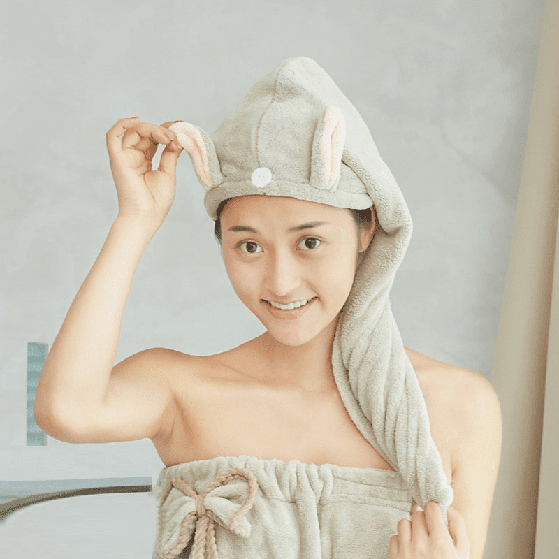 En kvinna har på sig en snabbtorkande huvudhandduk med kaninöron